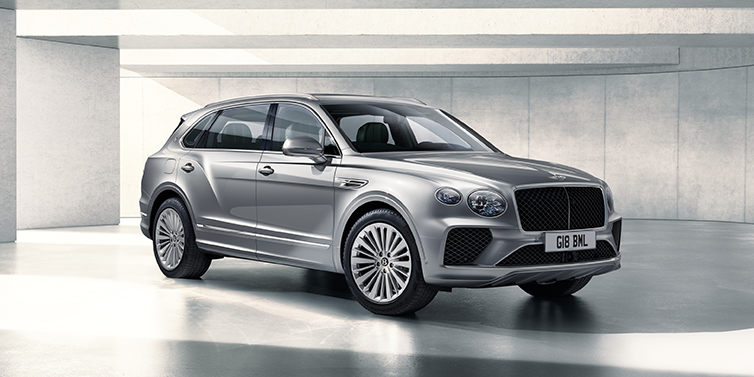 Bentley Köln Bentley Bentayga Extended Wheelbase SUV front three quarter in Moonbeam paint with a grey background